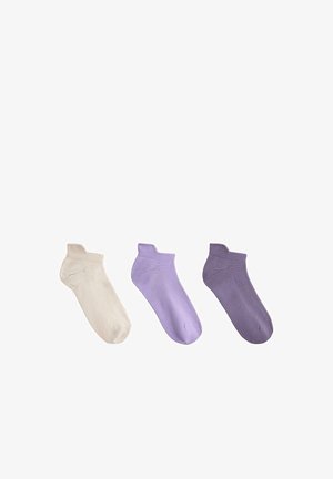 Trzy pary skarpetek do kostek w kolorach kremowym, jasnofioletowym i ciemnofioletowym, ułożone obok siebie na białym tle.
