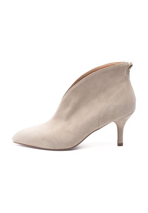 Beige Wildleder-Stiefelette mit spitzer Zehenpartie und schlankem Absatz. Mit einem seitlichen Reißverschluss und einer glatten, strukturierten Oberfläche.