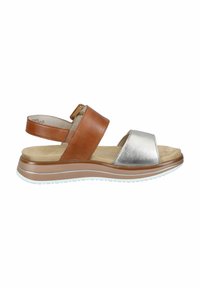 Brown leather sandal with silver metallic strap, adjustable ankle, cushioned sole, and a light brown outer sole with white accents.