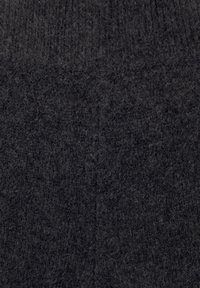 Tissu tricoté gris foncé avec une surface duveteuse et texturée montrant un détail en gros plan du motif tricoté.