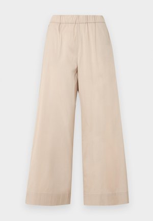 Beżowe spodnie o szerokich nogawkach z elastycznym pasem i prostym mankietem, pokazane na jednolitym jasnym tle.