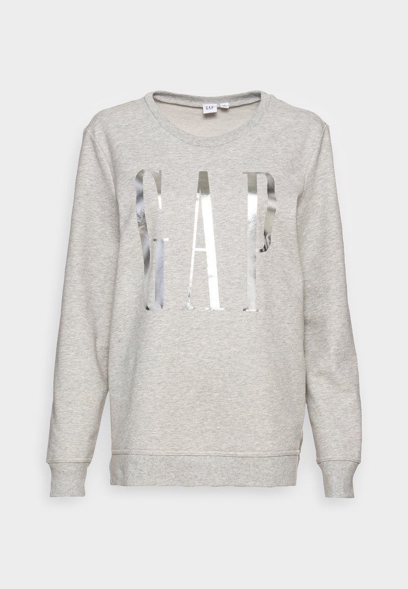 Sweat-shirt gris clair avec col rond, présentant un grand logo "GAP" réfléchissant argenté sur le devant et des poignets côtelés aux manches.
