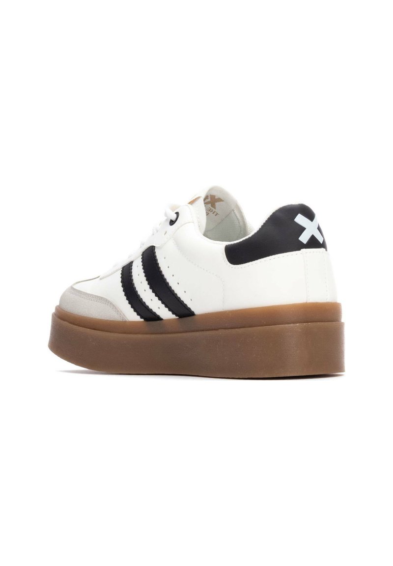 Białe sneakersy z czarnymi paskami, skórzany materiał, okrągły czubek, teksturowana beżowa platforma oraz kontrastujący czarny obcas z logo.