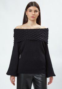 Schwarzer, schulterfreier Pullover mit gerippter Struktur und einem einzigartigen, erhabenen Muster am Ausschnitt; verfügt über lange Glockenärmel und eine lockere Passform.