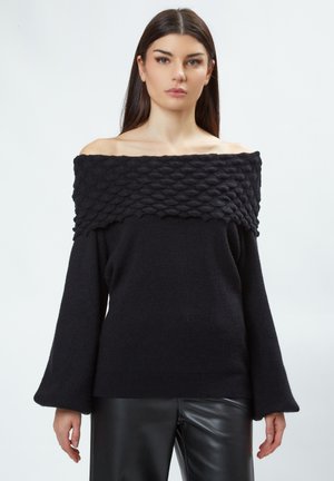Suéter negro sin hombros con textura acanalada y un patrón elevado único en el escote; cuenta con mangas acampanadas largas y un corte relajado.