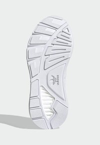 Biela podrážka tenisky so štruktúrovaným povrchom a vzorom so zigzagom, ktorý zvyšuje priľnavosť, a viditeľným logom značky embosovaným na boku.