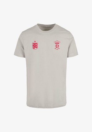 Light gray cotton t-shirt featuring pink graphic designs, including "2024" on the left and a crown and soccer ball on the right.