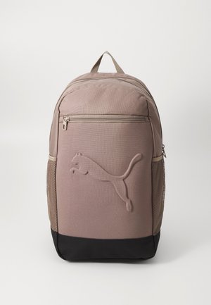 Brauner Stoff-Rucksack mit texturiertem Puma-Logo. Verfügt über eine Fronttasche, Netzseitentaschen und ein schwarzes Unterteil. Mit Reißverschluss.