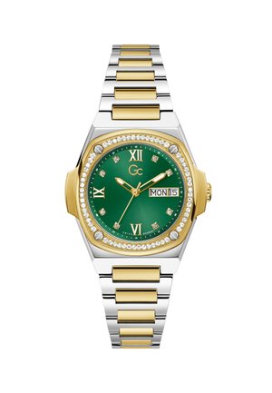 Arany és ezüst színű fémóra téglalap alakú tokkal, zöld számlappal, római számokkal, gyémánt díszítéssel és nap/dátum kijelzővel.