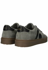 Pilki suede sportbačiai su juodais odiniais kulno akcentais, apvalia nosimi ir storu ruduoju padu. Yra mažas logotipas ant kulno ir šono.