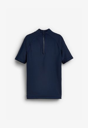 Jūras zila īsu piedurknu rash guard ar augstu apkakli un aizmugures rāvējslēdzēju. Gluda, elastīga auduma izstrādājums ar plakano šuvju komfortu.