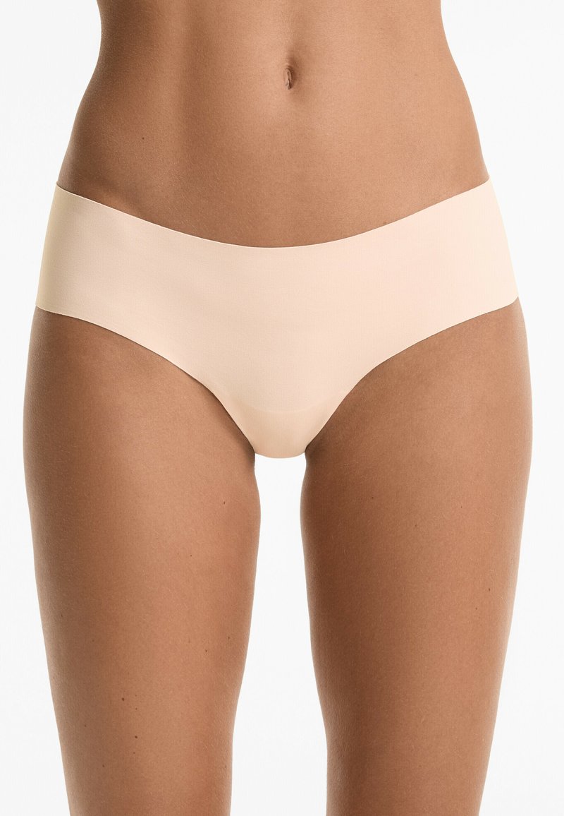 Beige naadloze hipster slipjes gemaakt van een soepele stof, met een brede tailleband en een minimalistisch ontwerp met een strakke afwerking.
