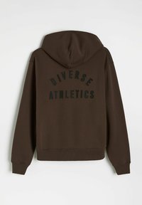 Brązowa bluza z kapturem i prążkowanymi mankietami oraz dołem. Na plecach widnieje napis "DIVERSE ATHLETICS" w wypukłych czarnych literach. Miękka tekstura.