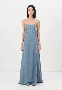 Denim maksi-kjole med tynne spaghetti-stropper, med en rett silhuett og kontrasterende sømmer langs sømmene. Myk blå farge.