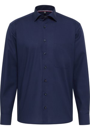 Marineblå langærmet skjorte lavet af glat stof. Har en spids krave, knappelukning fortil og en enkelt brystlomme. Tekstureret inderside af kraven.