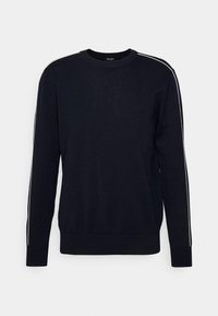 Pull noir à col rond à manches longues avec un léger liseré blanc le long des coutures des épaules et des manches, poignets et ourlet côtelés.