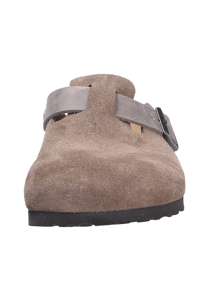 Chaussure slip-on en cuir suédé marron avec un bout rond, un détail de sangle et de boucle, et une semelle texturée. La tige a une finition lisse.