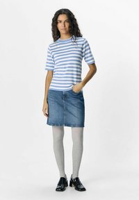 Top de manga corta a rayas azules y blancas, falda de mezclilla, pantys de canalé gris y zapatos negros de tacón, expuestos sobre un fondo sencillo.