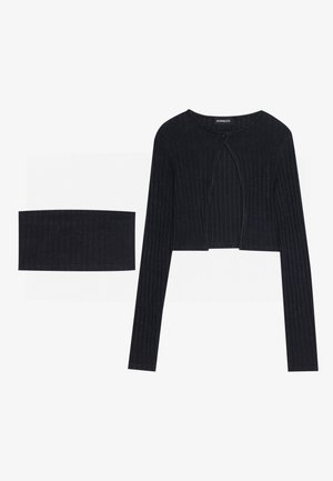 Black ribbed cropped top with long sleeves and a keyhole detail at the front, paired with a matching ribbed bandeau.