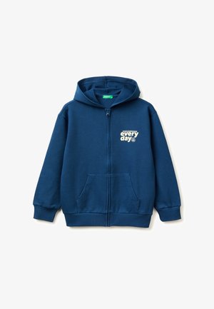 Sweat à capuche zippé bleu avec poches avant, poignets côtelés et texte blanc « going somewhere every day » sur le côté gauche de la poitrine.