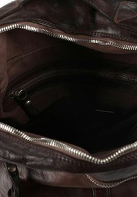 Interno di borsa in pelle marrone con tessuto testurizzato, molteplici tasche. Presenta una sezione con cerniera e una fodera liscia per un'organizzazione ordinata.