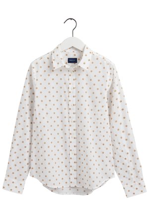 White long-sleeve button-up shirt with beige polka dots, displayed on a white hanger against a plain background.