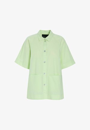 Chemise à manches courtes vert clair avec col, boutons ronds argentés et deux poches avant, présentée sur fond blanc.