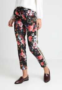 Blommönstrade byxor i svart, med en blandning av röda och rosa blommor; sidostråk i guld; lätt material med en slät yta.
