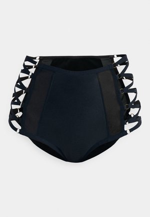 Högmidjade baddräktbottom i marinblått med meshpaneler och korskorsade remmar som är fästa med cirkulär hårdvara på sidorna.