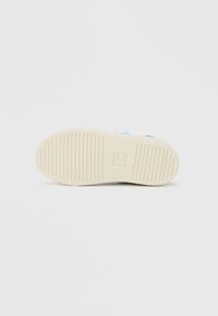 Kreemjas kummist jalanõu talla tekstuurse haardemustriga, mille keskel on peen logo. Ümar kuju, lame disain mugavuseks.