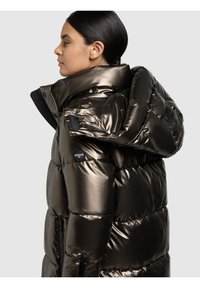 Metalna tamno smeđa jakna na puh s visokim ovratnikom, džepovima na zatvarač i logom na strani. Glatka, sjajna tekstura.