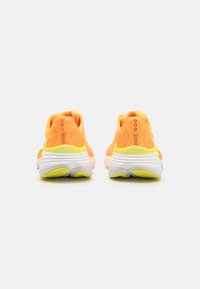 Baskets de sport orange avec une tige texturée, semelle intermédiaire blanche et semelle extérieure jaune vif. La vue arrière met en avant le détail de la fermeture éclair et la marque.
