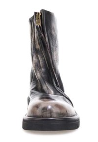 Mustat nahkaiset nilkkurit, joissa on terävä kärki, kiiltävä pinta, edessä näkyvä vetoketju ja tukeva, litteä kumipohja.