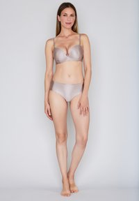 Ensemble de lingerie beige clair comprenant un soutien-gorge structuré côtelé avec bretelles réglables et un slip taille haute assorti, tous deux à la texture lisse.