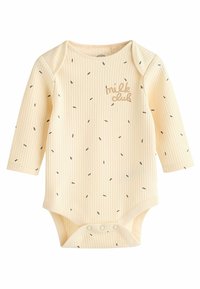 Lange mouwen baby bodysuit van zacht, lichtgeel ribbed materiaal. Voorzien van kleine zwarte zaadachtige patronen en de tekst "milk club" in beige. Drukknoopsluiting.