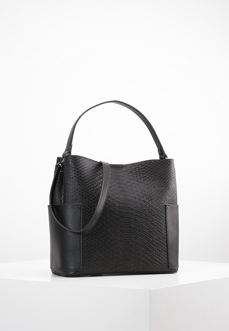 Sort håndtaske med et tekstureret slangeskinds mønster og glatte læderdetaljer. Den har et enkelt håndtag og to sidelommer.