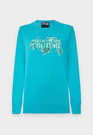 Jasnoniebieska bluza z długimi rękawami, ściągaczami przy mankietach oraz napisem "Versace Jeans Couture" ozdobionym zielonym wzorem paisley na przodzie.