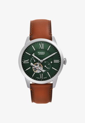 Montre-bracelet automatique Fossil avec cadran vert, mécanisme open-heart, chiffres romains argentés, et bracelet en cuir marron affichant l'heure 10h10.