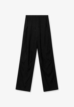 Schwarze, weit geschnittene Hosen aus weichem Stoff, mit einem elastischen Bund und Kordelzug sowie zwei seitlichen Taschen.