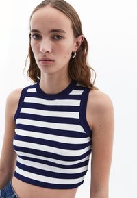 Top corto a righe con strisce orizzontali blu navy e bianche, texture a costine e design aderente con scollatura a girocollo.