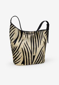 Bolso tote de pelo sintético con un patrón de rayas de cebra en crema y negro. Cuenta con una sola correa ajustable negra y una forma estructurada y amplia.