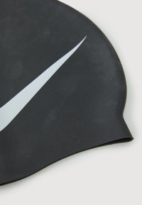 Bonnet de bain en silicone noir avec une texture lisse et un logo Nike en blanc bien visible. Bords courbés pour un ajustement serré.