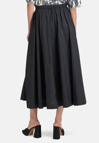 Schwarzer Maxi-Rock mit einem elastischen Taillenbund, aus leichtem Stoff gefertigt, mit glatter Textur und voller Silhouette am Saum.