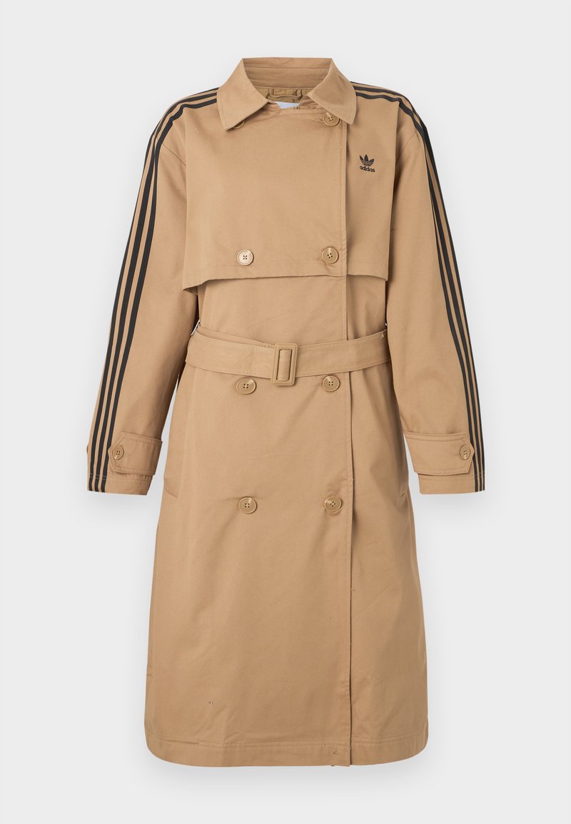 Beige trenchcoat med dobbeltradet design, sorte tre-stribe detaljer på ærmerne, bæltet talje og klassisk krave.