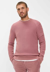 Helle rosa gestrickter Pullover mit Rundhalsausschnitt und langen Ärmeln, ausgestattet mit einem gerippten Textur und dezenten Nahtdetails.