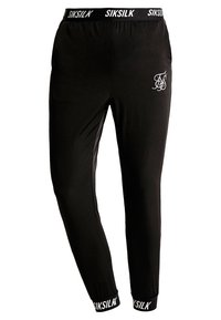 Schwarze Jogginghosen aus weichem Stoff. Mit einem elastischen Bund, der die SIKSILK-Marke trägt, und einem kleinen weißen Logo auf dem Oberschenkel. Eng anliegender Schnitt.