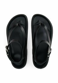 Sandali neri con suola piatta, realizzati in gomma liscia. Presentano cinturini neri con una fibbia metallica e un design minimalista.