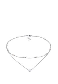 Zilveren ketting met twee gelaagde schakels, versierd met kleine roze kraaltjes en een centraal hartvormig pendant. Gladde textuur, minimalistisch ontwerp.