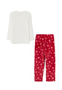 Weißes Langarmoberteil, kombiniert mit roten Hosen, die mit weißen Schneeflockenmuster verziert sind, beide aus weichem, plüschigem Stoff gefertigt.