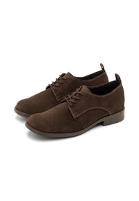 Pantofi din nubuc maro cu o textură netedă, prezentând un design clasic cu șireturi și o talpă din cauciuc. Cusăturile subtile accentuează designul.